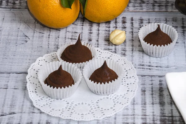 Deliciosos dulces de chocolate con avellana y mandarinas — Foto de Stock