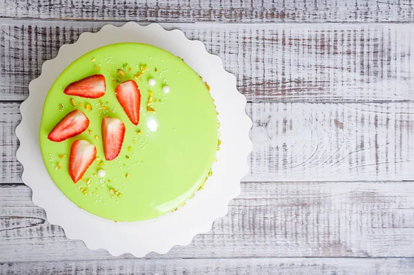 mirror glaze mousse cake with strawberries and pistachios