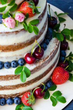 Meyveler ve çiçekler ile dekore edilmiş çıplak düğün pastası