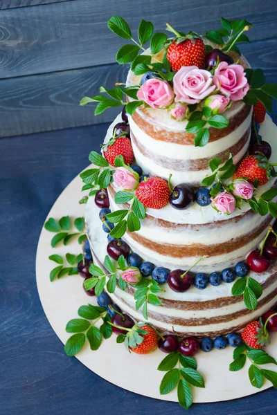 Gâteau de mariage nu décoré avec des baies et des fleurs — Photo