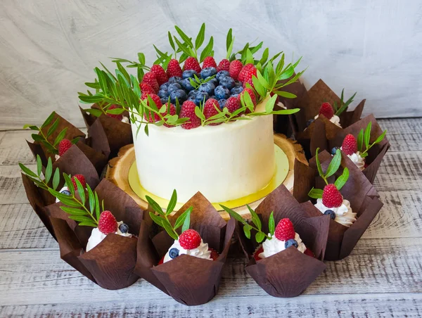 Berry svatební dort a červené sametové cupcakes — Stock fotografie