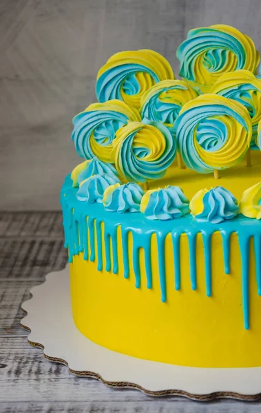 Bolo de gotejamento de cor de queijo creme amarelo e azul com merengues — Fotografia de Stock