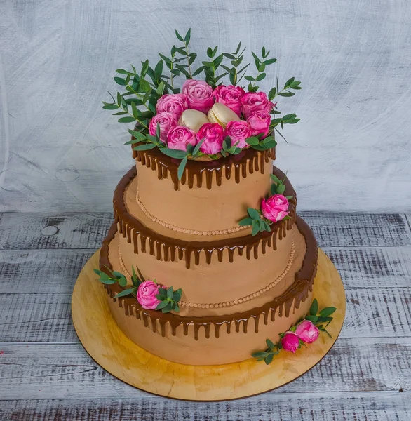 Three-tiered wedding chocolate drip cake decorated with roses — Stock Photo, Image