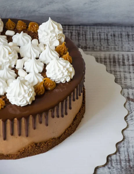 Chocolate drip cake with salted caramel and snow white merengues — Stock Photo, Image