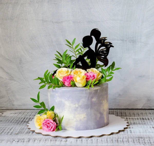 Gâteau d'anniversaire avec des roses sur le stand de gâteau — Photo