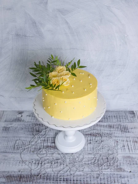 Pastel de queso crema amarilla con rosas y vegetación — Foto de Stock