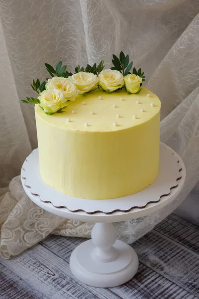 Bolo de queijo creme amarelo com rosas e vegetação — Fotografia de Stock