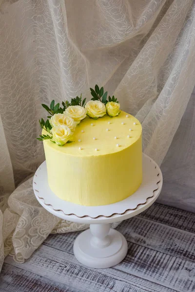 Yellow cream cheese cake med rosor och grönska — Stockfoto