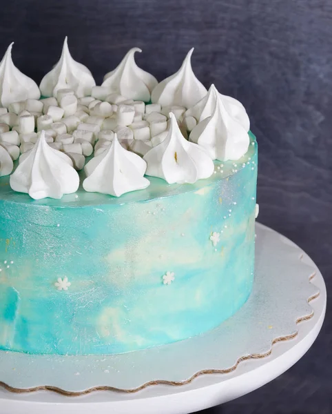 Light blue cream cheese cake with marshmallow and merengues