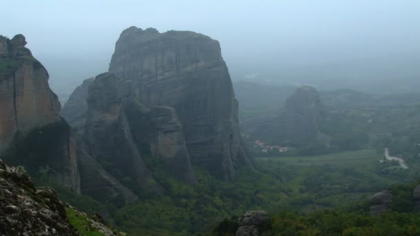 Pan-szerte a ködös kilátás nyílik a hegyekre és a Meteora kolostorok — Stock videók