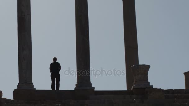 Turist står mellan kolumnerna i theatren på Leptis Magna, Libyen — Stockvideo