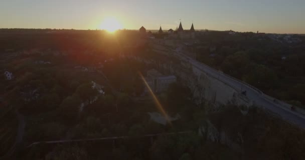 Cámara vuela hacia un atardecer Castillo de Kamianets-Podilsk — Vídeos de Stock