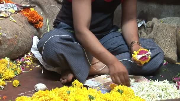 Ο άνθρωπος κάνει γιρλάντα από λουλούδια στην αγορά στην Γκόα, Ινδία — Αρχείο Βίντεο