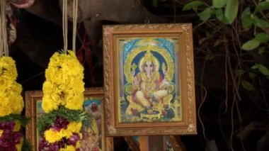 Çiçek ve küçük yol kenarında Hindu tapınak simgeleri