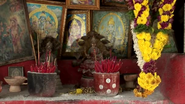 Цветы и иконы у маленького придорожного индуистского храма — стоковое видео