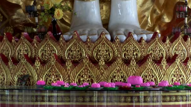 Candles burn at the base of a giant statue at the Dhammikarama Temple — Stock Video