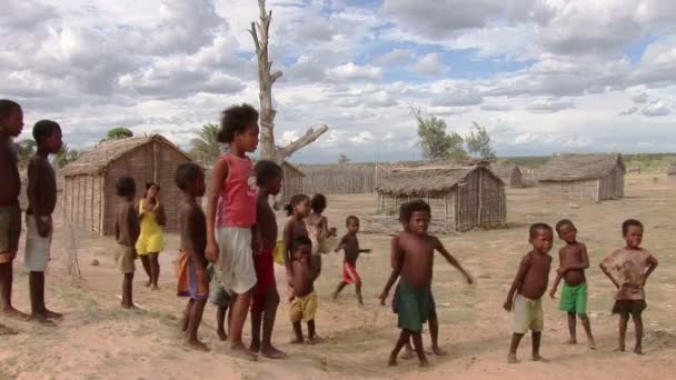 Дети улыбаются на камеру в отдаленной рыбацкой деревушке на юге Мадагаскара — стоковое видео