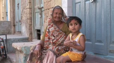 Büyükanne ve torunu kendi evinin önünde oturmak