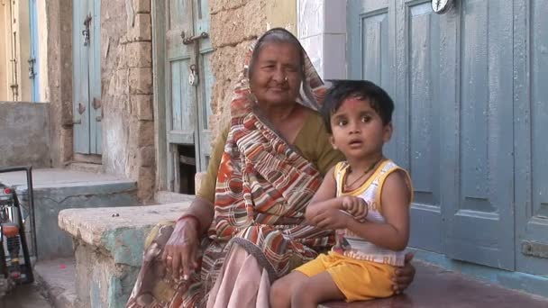 Büyükanne ve torunu kendi evinin önünde oturmak — Stok video