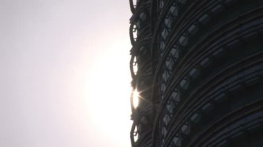 Biri olan Petronas Kuleleri ile parlayan güneş