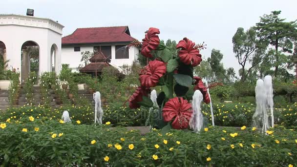 Eine blumenstatue und wasserspiel im botanischen garten perdana — Stockvideo