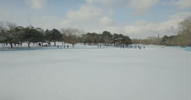 Caméra aérienne vole vers les gens qui patinent sur un lac gelé — Video