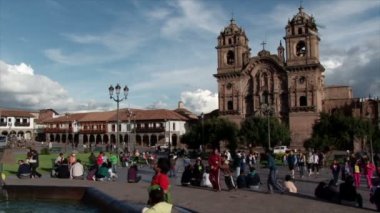 Plaza de Armas Cusco Katedrali arasında geniş görüş. Yerliler ön planda güneşinin keyfini çıkarın.