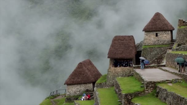 雲寝返り段々畑とマチュピチュの小屋 古代インカの遺跡のペルーのアンデス山脈 サイトを表示している観光客 — ストック動画