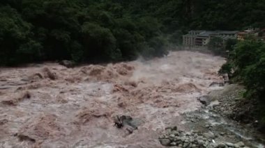 Machu Picchu, Peru yakın Aqua Calientes kasaba üzerinden geçerken Urubamba Nehri azgın sel sel tam