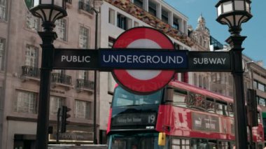Hem bir kırmızı ve yeşil çift katlı otobüs arka planda geçip olarak Piccadilly Circus Londra metro yakın çekim imzalamak