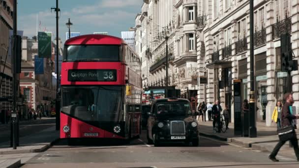在伦敦皮卡迪利广场的红绿灯处 近距离拍摄红伦敦巴士和黑色出租车 行人在前面交叉 — 图库视频影像
