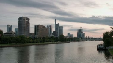 Ön planda Main Nehri ile Frankfurt manzarası karşısında şafakta geniş statik klip