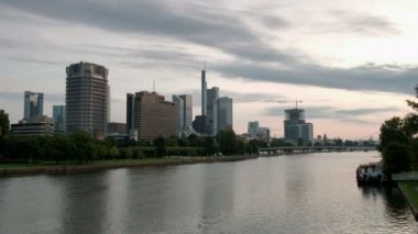 Ön planda Main Nehri ile Frankfurt manzarası karşısında şafakta geniş statik klip