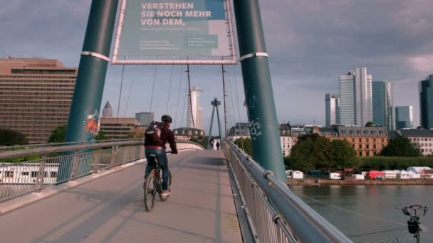 パンにフランクフルトのスカイライン Holbeinsteg 橋を渡るサイクリストから 夏の早朝の撮影 — ストック動画
