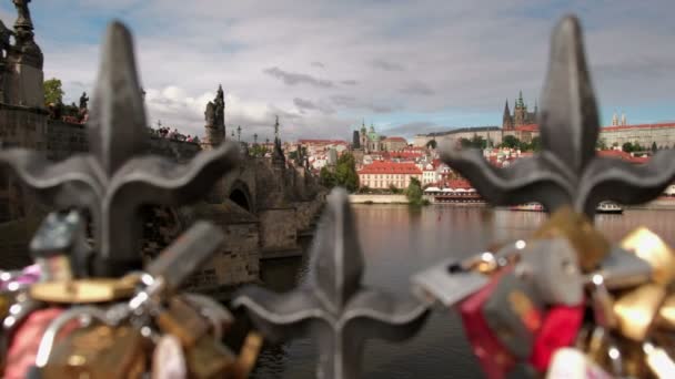 過去左カメラ スライド手すりと愛の Defocusses ロック 背景にはカレル橋とプラハ城です — ストック動画