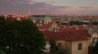 Çatıları ve gün batımında Prag manzarası karşısında yavaş yakın pan. Prag Kalesi alınan