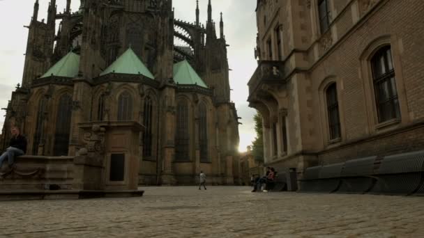 在布拉格城堡的圣圣维特大教堂后面的广场上 缓慢的滑动镜头 夕阳从大教堂后面爆裂出来 — 图库视频影像