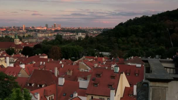 Pomalu při západu slunce blízko pan celé střechy a panorama Prahy. Převzato z Pražského hradu