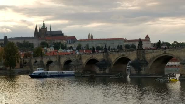 Pomalé posouvání přes Karlův most od Pražského hradu v podvečer jako turistická loď prochází pod