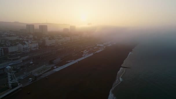 Drone Flyger Baklänges Genom Dimmig Soluppgång Att Avslöja Brighton Beach — Stockvideo