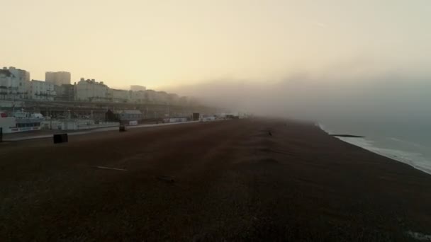 Drone Flyger Fram Och Stiger Dimmig Soluppgång Över Brighton Beach — Stockvideo