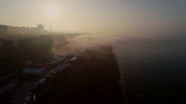 Drone geriye doğru Sussex'te Brighton Plajı'nda güzel sisli gün doğumu ile uçar