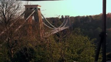 Kamera jib stil Clifton asma köprü Avon İngiltere'de ortaya çıkarmak için parmaklıklar arkasından yükselir. Bahar akşam atış
