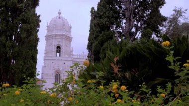 Portekiz, Lizbon 'da ağaçlarla çerçevelenmiş Santa Maria de Belem kilisesinin süslü çan kulesi.