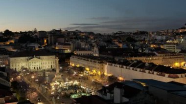 Alacakaranlıkta Lizbon 'daki Rossio Meydanı' nın yüksek statik görüntüsü. Meydanda yoğun bir gıda pazarı görülebilir.