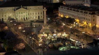 Geceleri Lizbon 'daki Rossio Meydanı' nın yüksek statik görüntüsü. Meydanda yoğun bir gıda pazarı görülebilir.