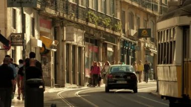 Lizbon / Portekiz - 19 Mayıs 2019: Lizbon şehir merkezinde insanlarla birlikte Rua do Loreto caddesi boyunca uzanan eski usul tramvayın telefoto klibi