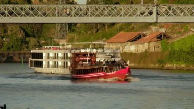 Bir turist haham teknesi Porto, Douro nehri kıyısındaki Ponte Luis nehrinin altından geçiyor.