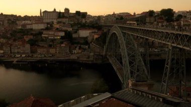Tramvay, arabalar ve yayalar gün batımında Porto 'daki Ponte Luis Köprüsü' nden geçiyor. Bir bahar akşamı çekildi. 