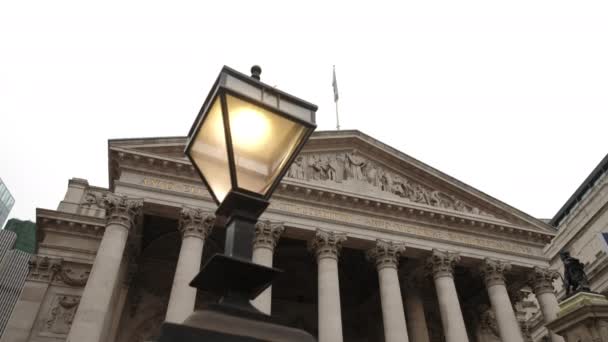 照相机从旧灯后面滑行 露出伦敦皇家交易所的立面 — 图库视频影像